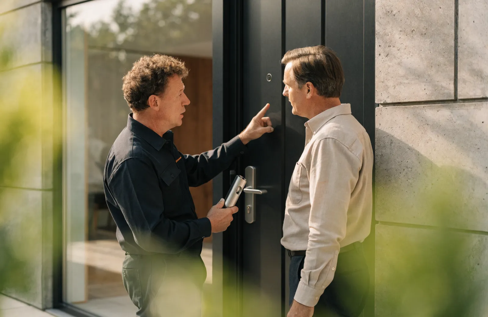 A certified locksmith advising a homeowner at their front door